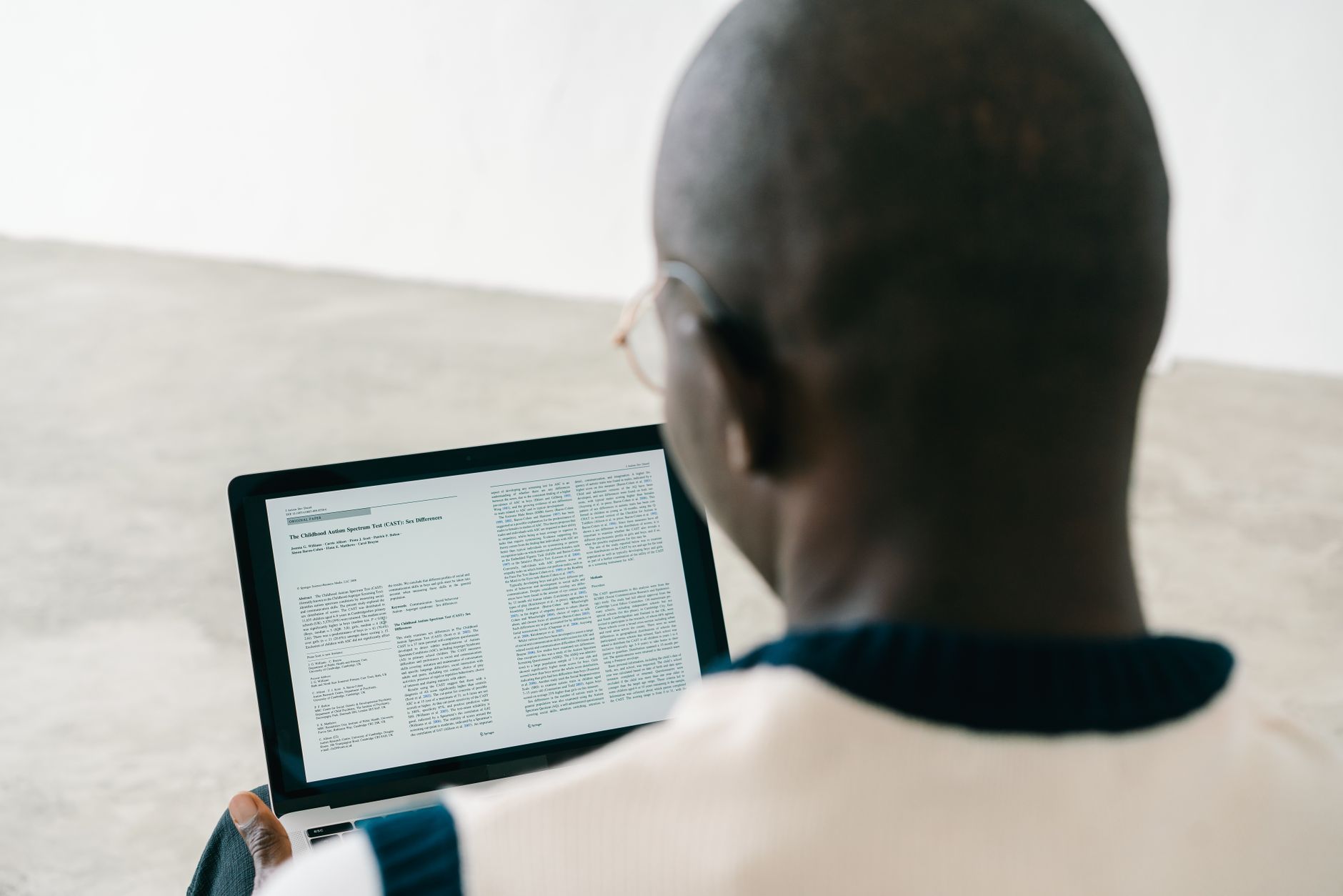 Person reading a document on a laptop screen.